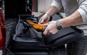 Person putting a rifle into BONE-DRI Rust Prevention Dual Rifle Case