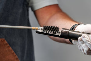 Man cleaning the barrel of a rifle 